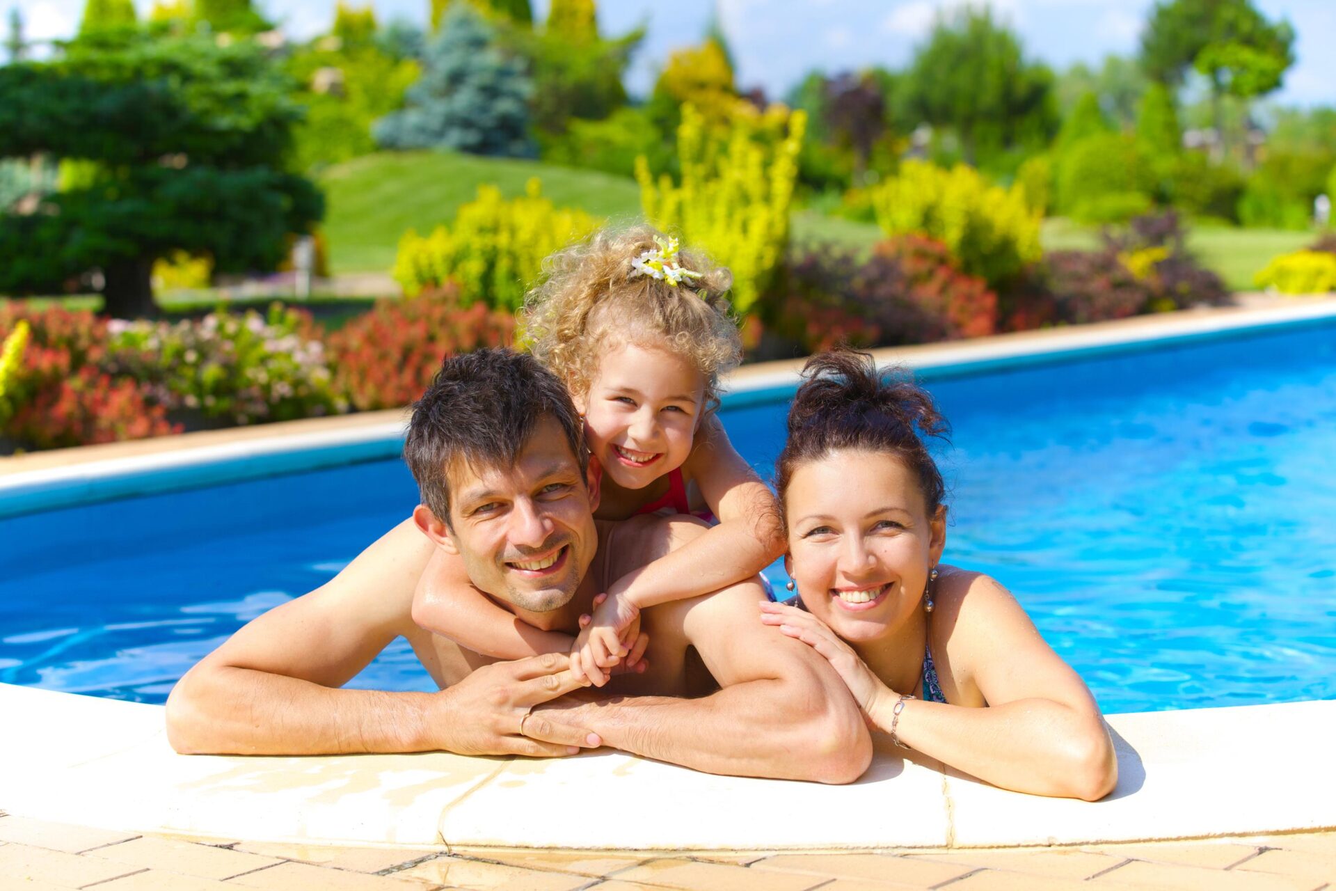 A man, a woman, and a child in a pool