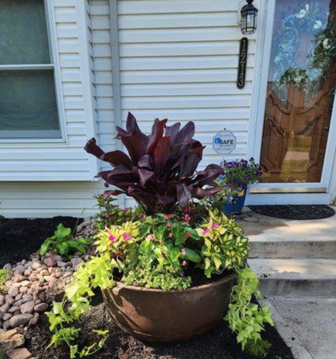 A planter of seasonal color plants by steps.