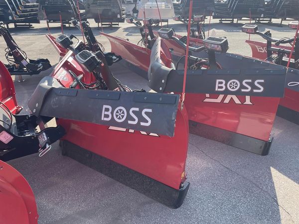 A line of snow plows in a parking lot.