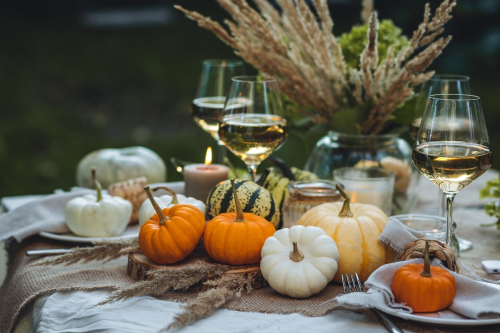 Thanksgiving themed table decorations like pumpkins and wheat sheafs